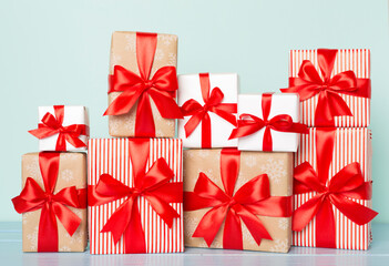 Gift boxes with red ribbon bow on color background