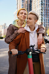 Blonde and a brunette ride together on scooter around city