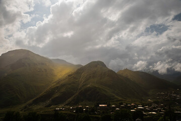 Stepancminda Gruzja widok latem w stronę góry Kazbek przy częściowym zachmurzeniu.