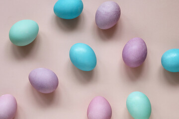 festive backdrop with colorful Easter eggs on a pink background, top view.