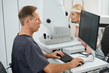 Fototapeta na wymiar Close-up photo of male doctor testing patient eyes
