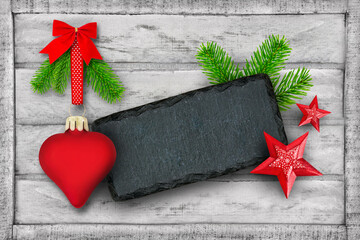 Weihnachten und rote Dekoration mit Herz, Tannenzweigen und Label auf Holz