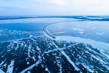 Breakwater leading into Baltic sea at winter. Sea covered in fog and ice blocks.