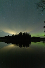 HInt of Aurora borealis in the horizon by the lake in Finland