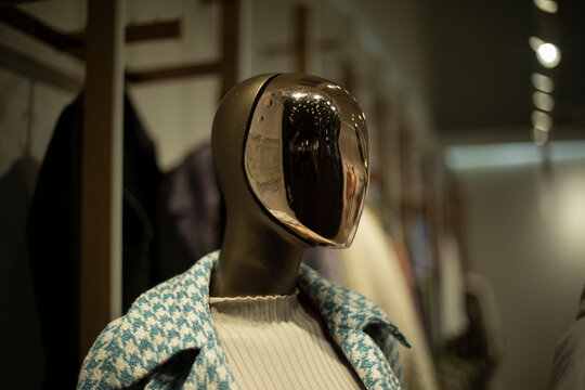 Golden mask on face. Mannequin in clothing store. Figure of person without face.