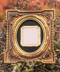 Isolated golden tintype picture frame. Old tintype frame  is in the center surrounded by modern oval frame with embossed  floral design.