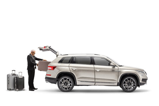 Businessman putting suitcase in the trunk of a SUV - Powered by Adobe