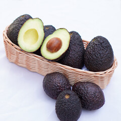 Whole and cut avocados on white background