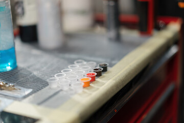 The process of pouring tattoo ink into a container, tattoo studio. Tattoo artist in studio preparing