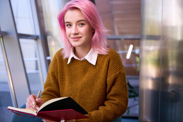 Close-up photo of woman making notes in the book