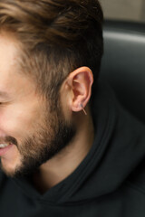 Obraz premium Tattoo piercing studio - a woman makes an ear piercing to a man to a guy