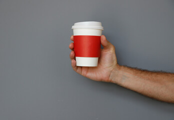 Male hand holding coffee mug, isolated, plain background