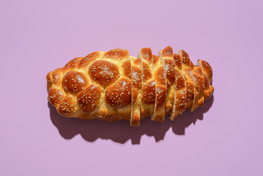 Sliced challah bread top view on a purple background