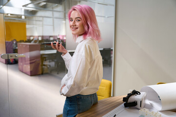 Smiling woman standing in the office and talking