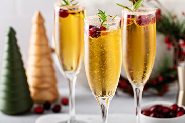 Festive Christmas mimosa with apple cider and cranberries