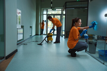 Team of certified janitors doing their best to clean building