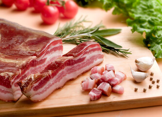 smoked loaf cut into cubes on a wooden cutting board with garlic and pepper