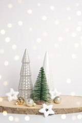 Modern Christmas trees. Decorative Beige, White and Green Christmas Decoration on a Wooden Stand with a Gray background. Nordic Festive Decor. Boho, Scandinavian Style Design. Trendy Minimal Ornament.