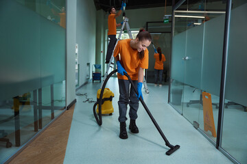 Friendly team of professional cleaners working hard tidying up