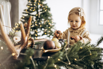 Cute baby girl by the christmas tree