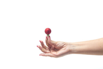 Uma mão feminina, com unhas pintadas de vermelho, segurando uma bola de Natal vermelha com fundo...