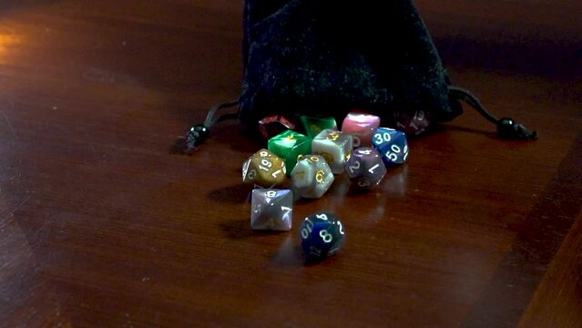 Dice slowly being poured from a bag.