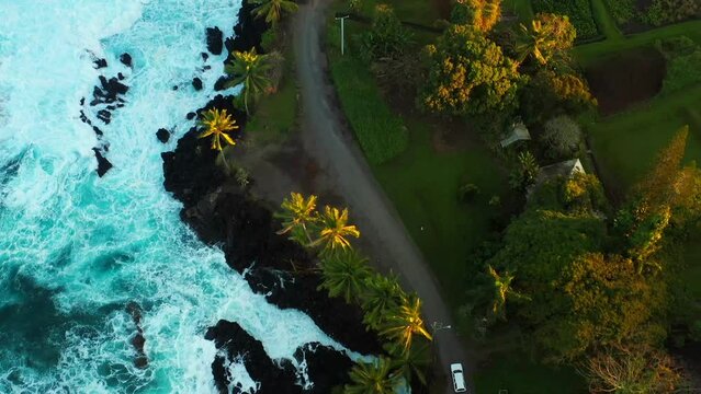 Top down shot of Car driving next to ocean waves in road to Hana, Maui, Hawaii
