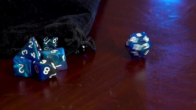 A hand spins a twenty sided dice.