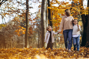 Fototapeta premium Mother with children having fun in autumn park