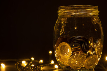 Glass jar with euro coins on a dark background with led lights. Euro pocket savings coin concept....
