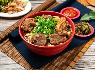 beef noodles with green onion and chili sauce served in a bowl isolated on table top view of...