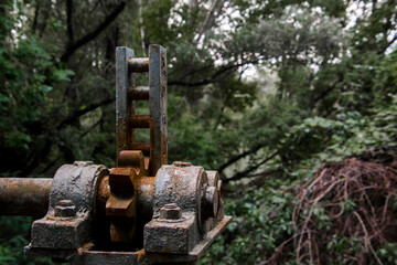 Rusty gear of an old dam in the forest