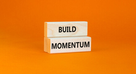 Build momentum symbol. Concept words Build momentum on wooden blocks. Beautiful orange table orange...
