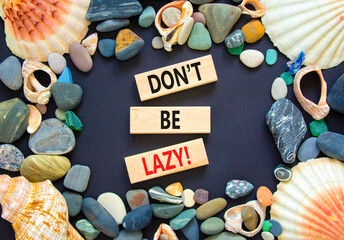 Motivational and do not be lazy symbol. Concept words Do not be lazy on wooden blocks on a beautiful black table black background. Sea shell and stone. Business do not be lazy concept. Copy space.