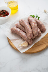 uncooked bbq sausage on wooden board