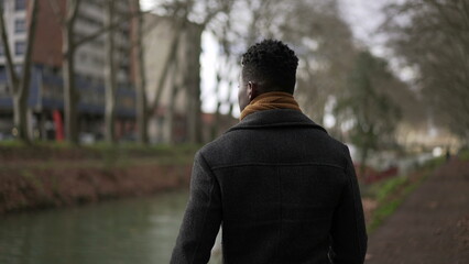 Elegant black man walking outside in nature park during winter season2