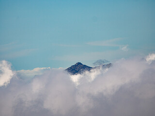 mountain peaks behind clouds