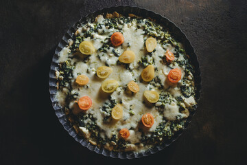 homemade tart pie with spinach, fresh tomatoes and basil leaves