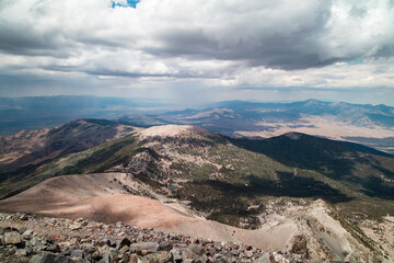 Rain clouds over Great Basin National Park as seen on a summer day from the summit of Wheeler Peak facing north. Stella Lake and Bald Mountain are seen in the distance. Located near Baker, Nevada.