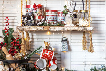 Table in the kitchen with kitchen utensils and shelves decorated with Christmas toys