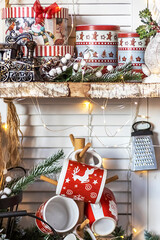 Table in the kitchen with kitchen utensils and shelves decorated with Christmas toys