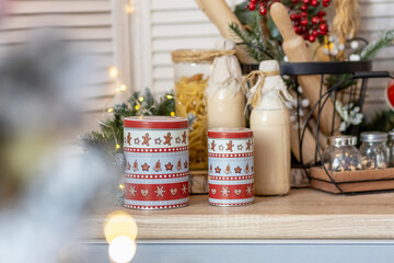 Table in the kitchen with bottles of milk, cups and Christmas decorations