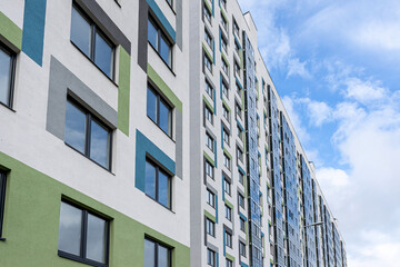 facade of a new building of white blue and green color with glass windows and balconies