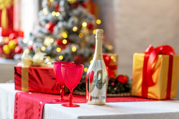 Champagne bottles and glasses on the table against the backdrop of Christmas decorations