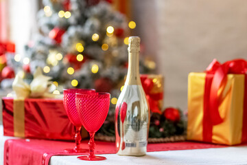 Champagne bottles and glasses on the table against the backdrop of Christmas decorations