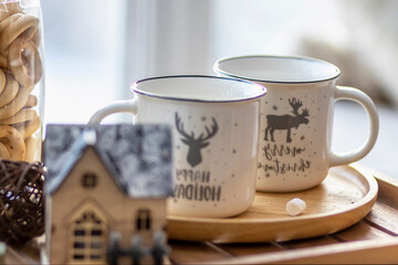 Morning Christmas coffee with marshmallows and Christmas decorations on a tray table by the window on the windowsill