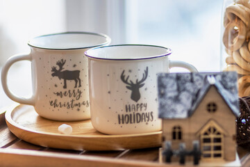 Morning Christmas coffee with marshmallows and Christmas decorations on a tray table by the window on the windowsill
