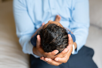 A father holding his newborn baby in his hands