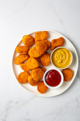 Overhead view of chicken nuggets on light surface