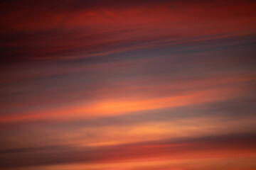 Red clouds on a dramatic colorful cold winter sunset sky, warm tones, Germany, Europe